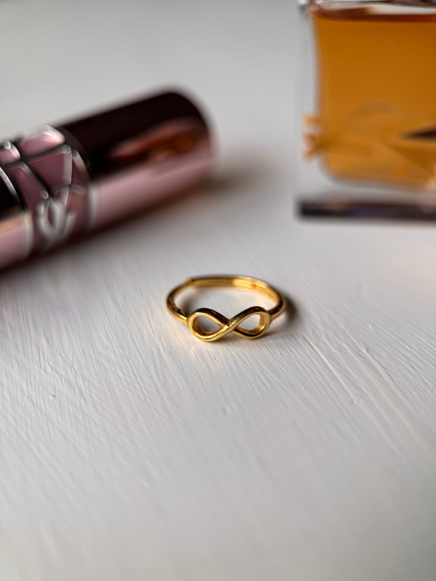 Autism ring with lipstick and perfume in the background