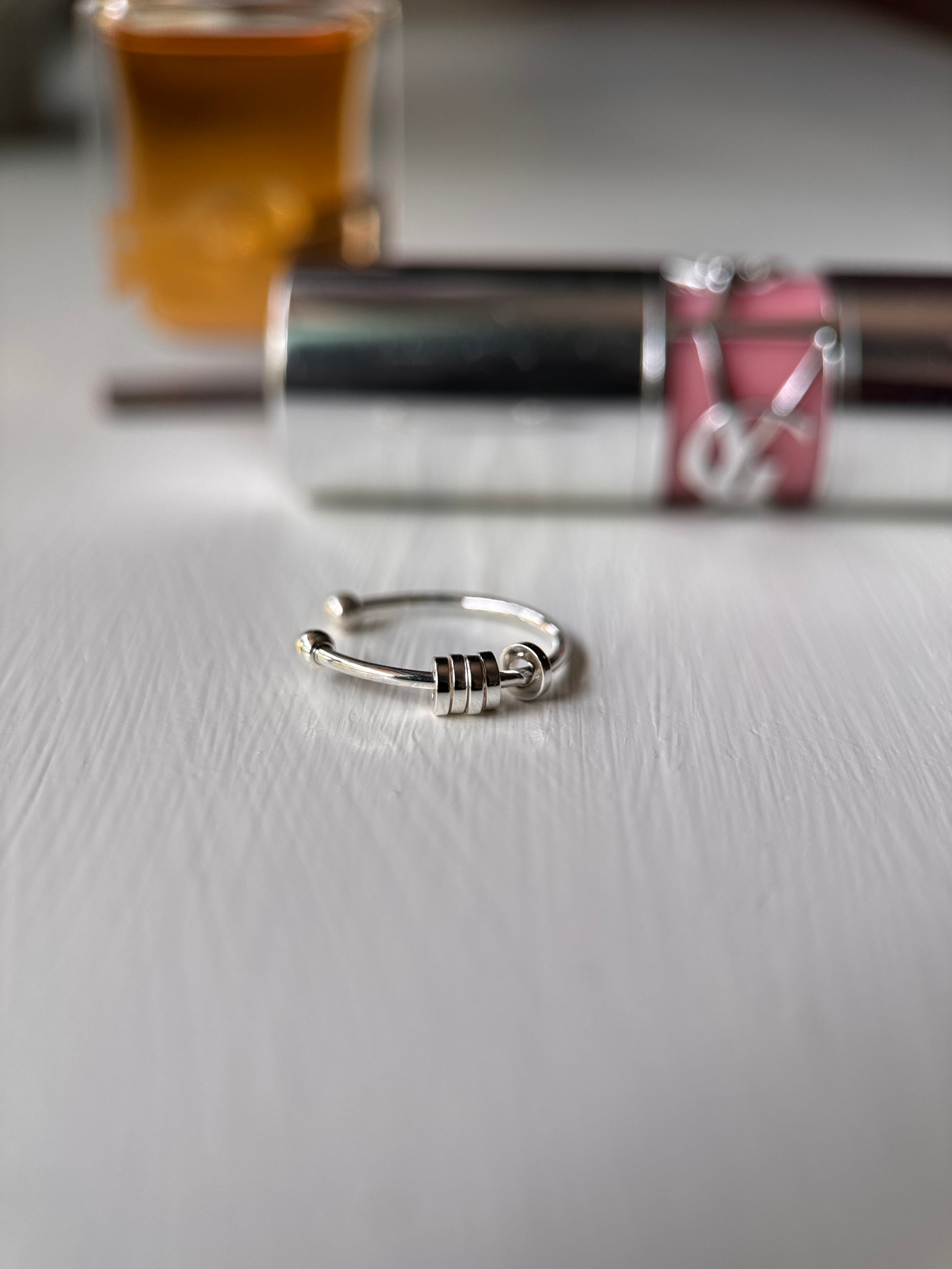 Subtly anxious kids anxiety ring roller fidget Close up with makeup in the background