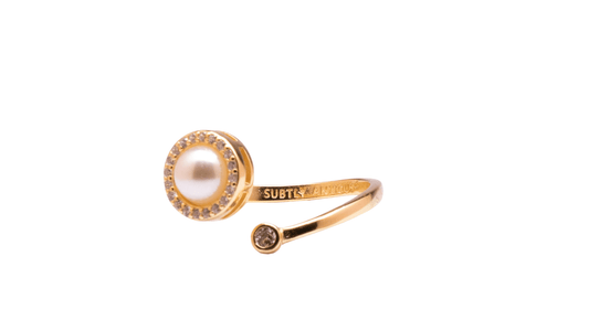 Gold ring with a pearl and small gemstone on a white background